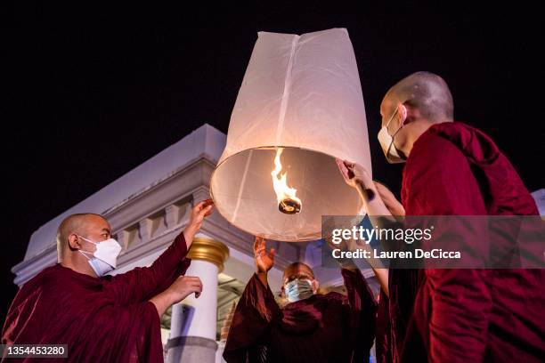 Thai monks launch 'khom loy', lanterns, into the sky during the Yee Peng Festival on November 20, 2021 inLamphun, Thailand. The Gassan Panorama Golf...