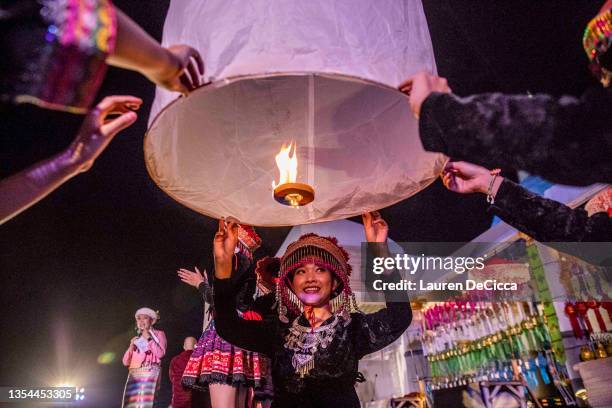 Thai traditional dancers launch 'khom loy', lanterns, into the sky during the Yee Peng Festival on November 20, 2021 inLamphun, Thailand. The Gassan...
