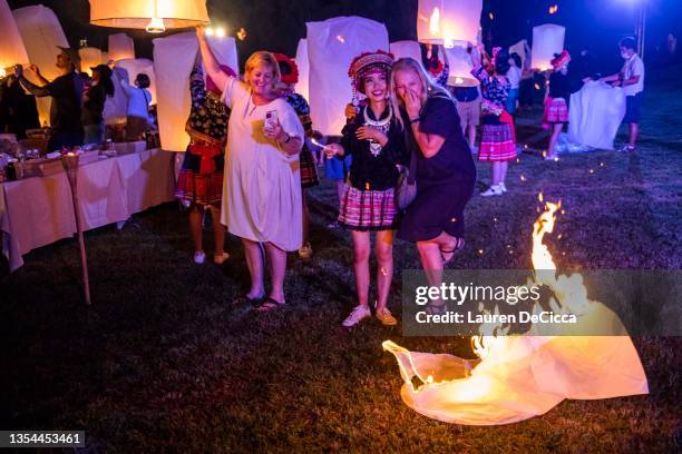 Tourists laughs with a Thai traditional dancer as her lantern burns to the ground during the Yee Peng Festival on November 20, 2021 inLamphun,...
