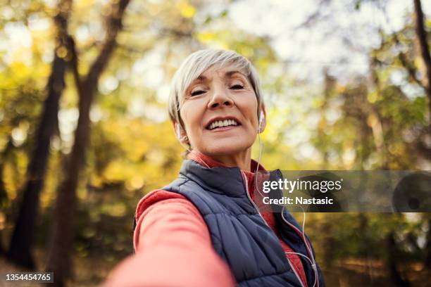 smiling senior woman making selfie - walking toward camera stock pictures, royalty-free photos & images