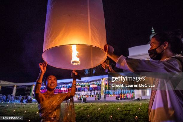 Couple launches 'khom loy', lanterns, into the sky during the Yee Peng Festival on November 20, 2021 inLamphun, Thailand. The Gassan Panorama Golf...