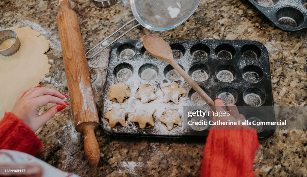 Top down image of homemade mince pies in a baking tray, ready to go in the oven