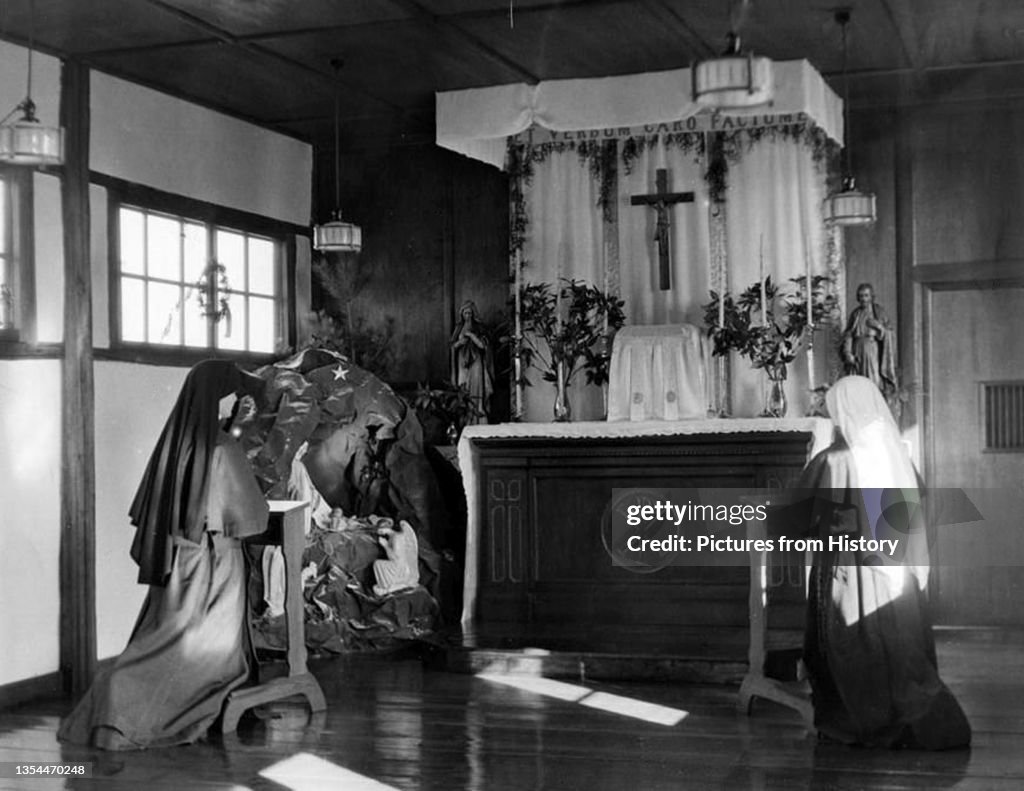 Korea: Convent altar, Heijo (Pyongyang) ca. 1939. Two Sisters kneel in front of the convent altar decorated for Christmas. To the left of the altar is a nativity scene behind which stands an evergreen tree. A <i>Chi-Rho</i> adorns the altar.