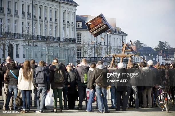 Members of the public look at a piano throw with a catapult during a Royal de Luxe street theatre performance in Nantes, western France, on December...