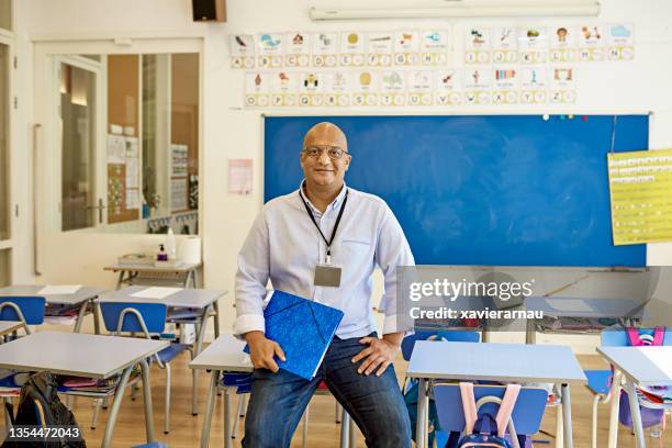 casual portrait of elementary school teacher in classroom - classroom male stock pictures, royalty-free photos & images