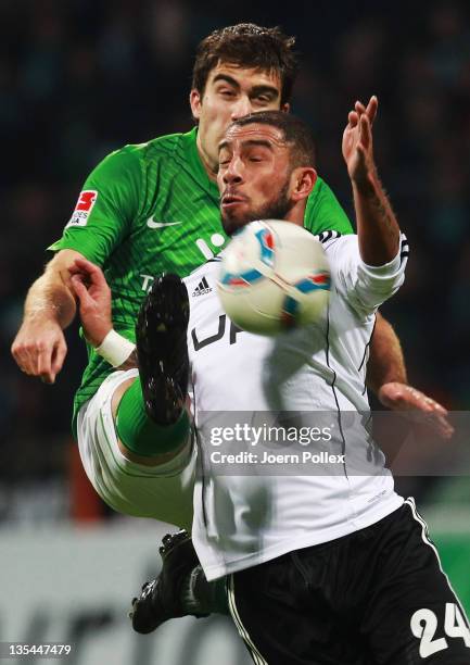 Sokratis Papastathopoulos of Bremen and Ashkan Dejagah of Wolfsburg battle for the ball during the Bundesliga match between SV Werder Bremen and VfL...