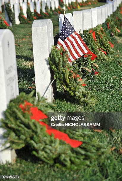 Flag and holiday wreaths are placed on tombstones of US military veterans at Arlington National Cemetery in Arlington, Virginia, on the outskirts of...