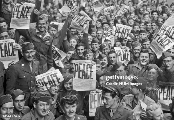 Day - Soldiers hold up the Stars and Stripes newspaper in celebration of the end of WWII in Europe May 8, 1945.