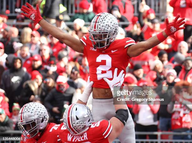 Chris Olave of the Ohio State Buckeyes celebrates a first half touchdown catch against the Michigan State Spartans with Luke Wypler of the Ohio State...