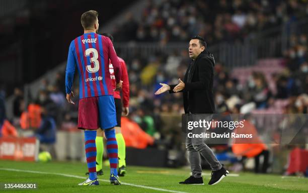 Xavi Hernandez, Head Coach of FC Barcelona reacts on the sidelines with Gerard Pique of FC Barcelona during the La Liga Santander match between FC...