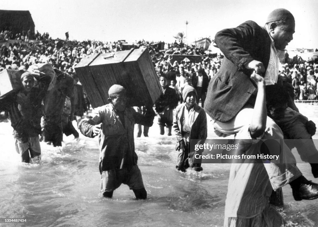 Israel / Palestine: Palestinians driven from their homes and fleeing via the sea at Acre by Israeli forces, 1948