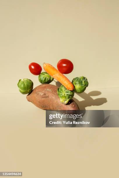 vegetables stack- tomatoes, brussels sprouts, carrot and sweet potato on the beige background - vegetarian food pyramid stock pictures, royalty-free photos & images