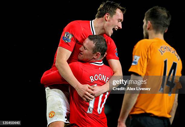 Wayne Rooney of Manchester United is congratulated by teammate Phil Jones after scoring his team's fourth goal as a dejected Roger Johnson of Wolves...