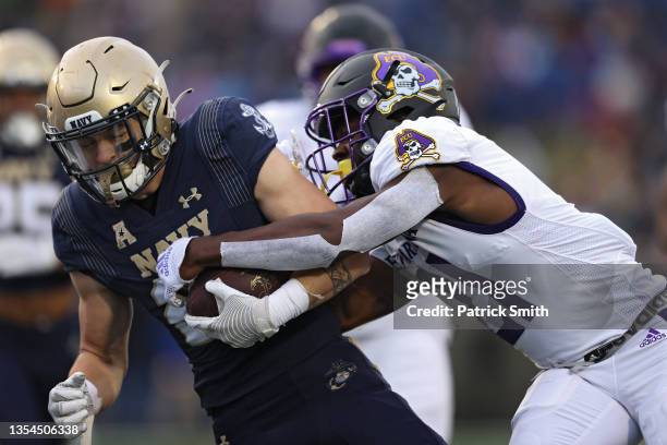 Fullback Kai Puailoa-Rojas of the Navy Midshipmen is tackled by cornerback Ja'Quan McMillian of the East Carolina Pirates during the first half at...