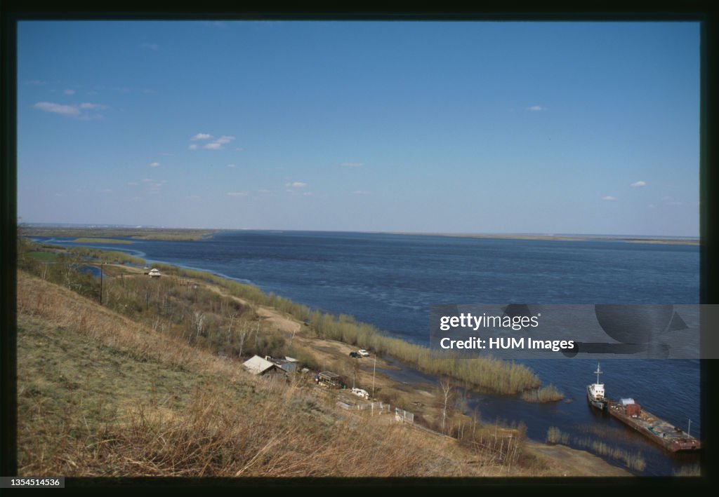 Boat and barge on the Lena River, Farm on shore, view toward Yakutsk from the south, Yakutsk, Russia; 2002