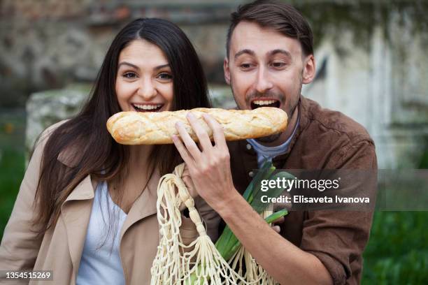 young couple eating bread - mascar imagens e fotografias de stock