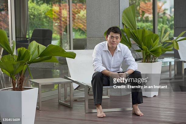 businessman with relaxing, sitting on lounger - asian man barefoot foto e immagini stock