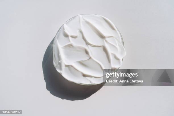 petri dish full of white smears of cream on gray background. concept of cosmetics laboratory researches. photography in flat lay style - skin care ingredients stock pictures, royalty-free photos & images