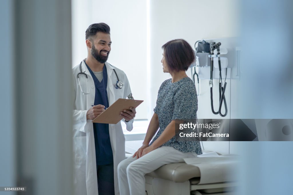 El adulto mayor habla con el médico sobre una vacuna contra la gripe