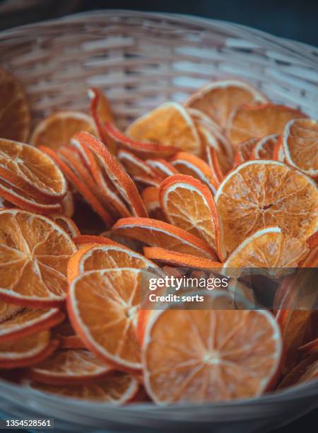 bunch of aromatic dried orange & lemon slices in a wooden basket - dried food stock pictures, royalty-free photos & images