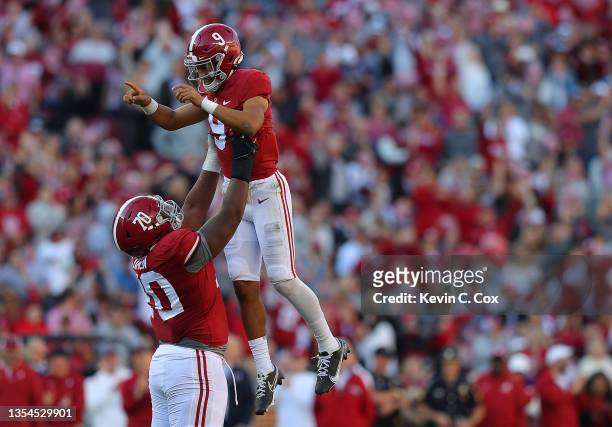 Bryce Young of the Alabama Crimson Tide reacts after passing a touchdown to John Metchie III against the Arkansas Razorbacks with Javion Cohen during...