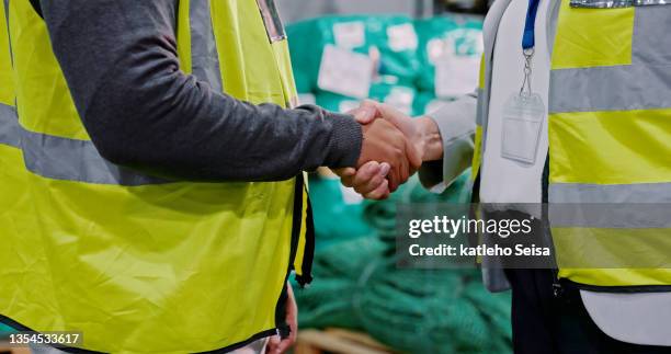 closeup shot of an unrecognisable man and woman shaking hands while working in a warehouse - warehouse safety stock pictures, royalty-free photos & images