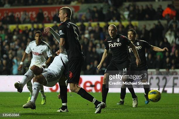 Danny Graham of Swansea City hooks in the second goal as Brede Hangeland of Fulham fails to block during the Barclays Premier League match between...