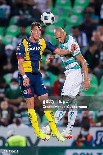 Andres Vombergar of San Luis struggles for the ball with Matheus Doria of Santos during the repechage match between Santos Laguna and Atletico San...