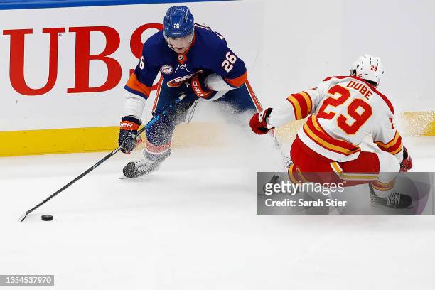 Oliver Wahlstrom of the New York Islanders skates with the puck as Dillon Dube of the Calgary Flames defends during the second period at UBS Arena on...