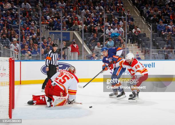 Mathew Barzal of the New York Islanders is stopped during the second period by Jacob Markstrom of the Calgary Flames at the UBS Arena on November 20,...