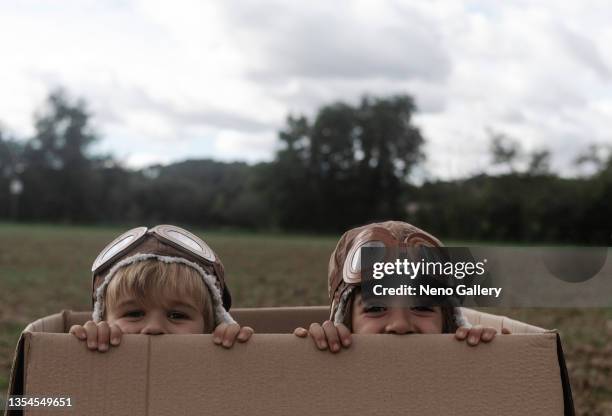 brothers playing inside a box looking at camera - aviation hat stock pictures, royalty-free photos & images