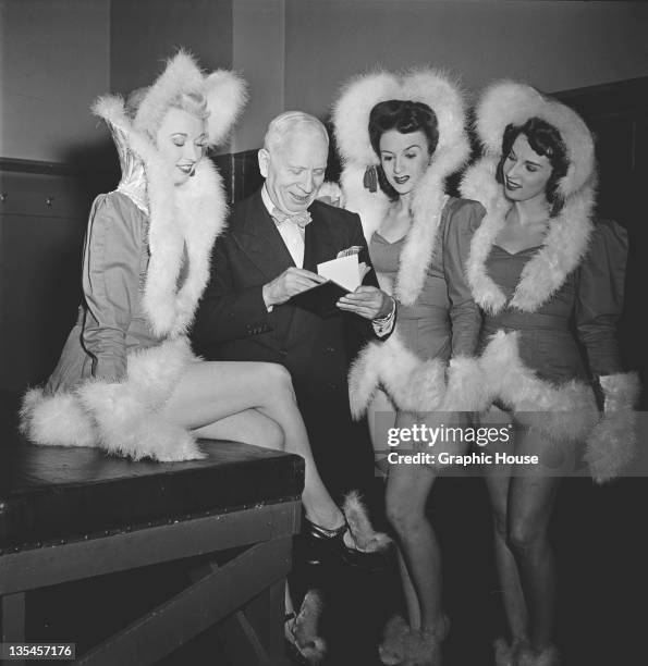 Members of The Rockettes precision dance company with a fan backstage at the Radio City Music Hall in Manhattan, New York City, circa 1950. The...