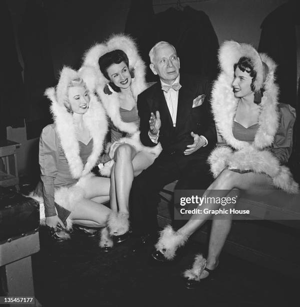 Members of The Rockettes precision dance company with a fan backstage at the Radio City Music Hall in Manhattan, New York City, circa 1950. The...