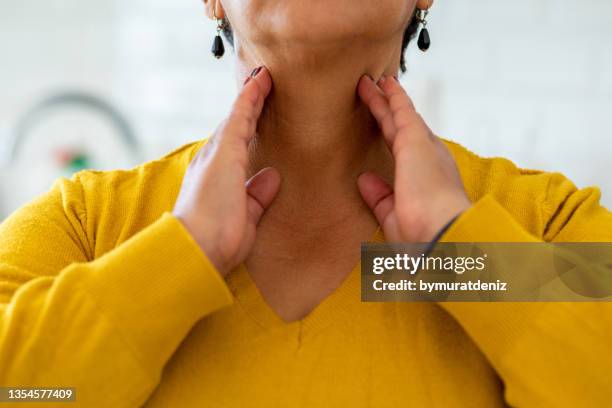 femme avec un problème de glande thyroïde - gorge cou photos et images de collection