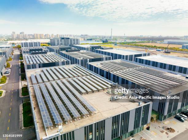 aerial view of solar panels on factory roof. blue shiny solar photo voltaic panels system product. - factory stockfoto's en -beelden