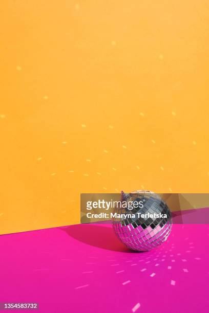 gray disco ball on an orange-pink background. - silver disco ball stock pictures, royalty-free photos & images