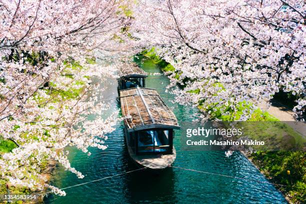 boats tied up on the uji canal in kyoto city - région de kinki photos et images de collection
