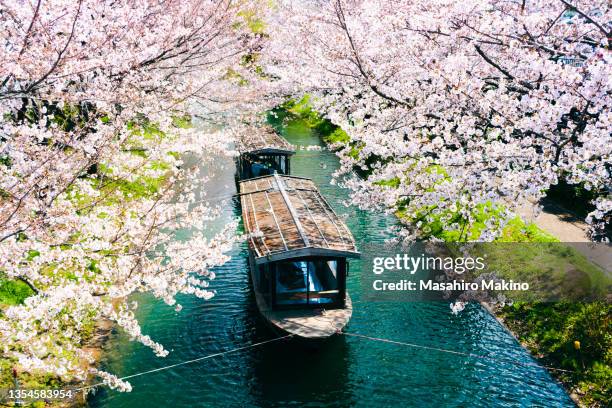 boats tied up on the uji canal in kyoto city - kyoto imagens e fotografias de stock