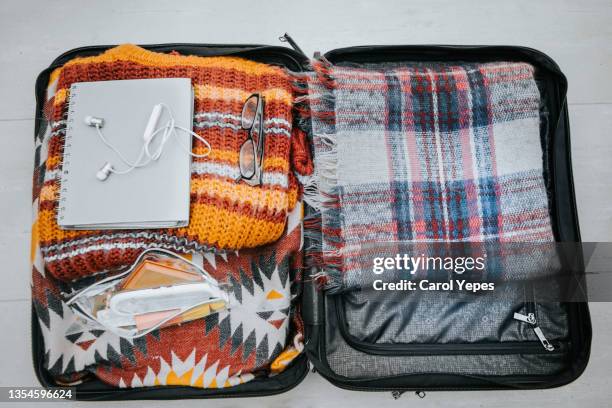 packing up for winter holiday: an open suitcase full of clothes and other objects ready to be packed - suitcase from above stock pictures, royalty-free photos & images