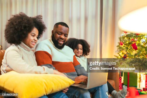 black african family enjoy time together while using phone for playing and video call,african american family gather to celebrate and enjoy traditional holiday dinner or lunch thanksgiving or christmas - virtual thanksgiving stock pictures, royalty-free photos & images