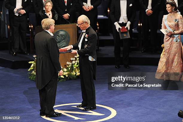 Australian astrophycisist Brian Schmidt receives the Nobel Prize for Physics from King Carl XVI Gustaf of Sweden as Queen Silvia of Sweden looks on...