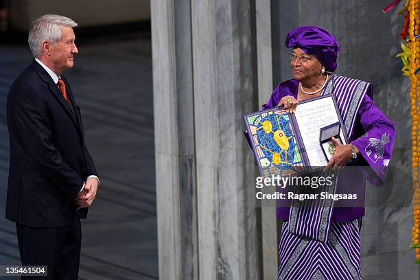 Chairman of the Nobel Committee Thorbjoern Jagland watches joint winner Liberian President Ellen Johnson Sirleaf hold her award during the Nobel...