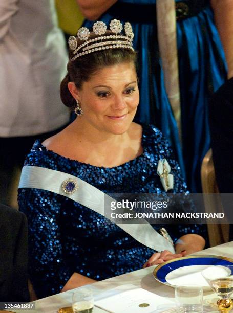 Swedish Crown Princess Victoria reacts at the honorary table during the Nobel banquet following the Nobel Prize award ceremony held at the Stockholm...