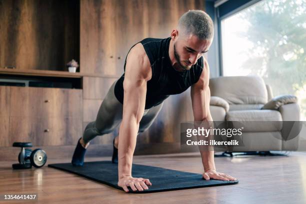 muscular athletic young man training for body building at home - joint effort stock pictures, royalty-free photos & images