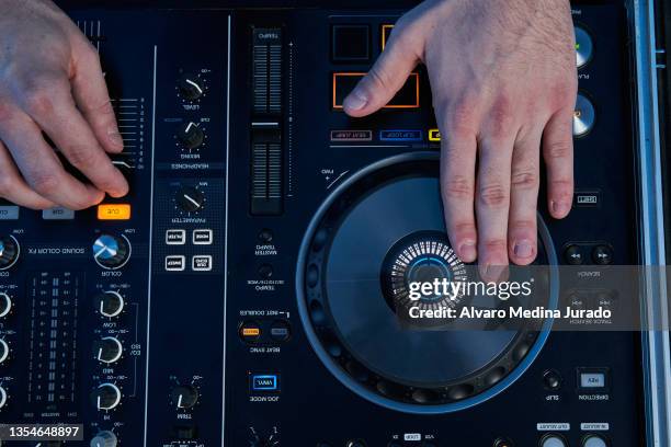 top view of unrecognizable male dj hands playing music in a session with a mixer. - mixage du son photos et images de collection