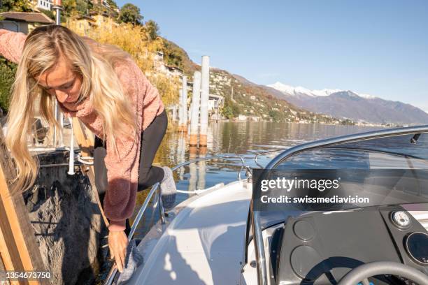 giovane donna che attracca la barca al molo - attraccato foto e immagini stock