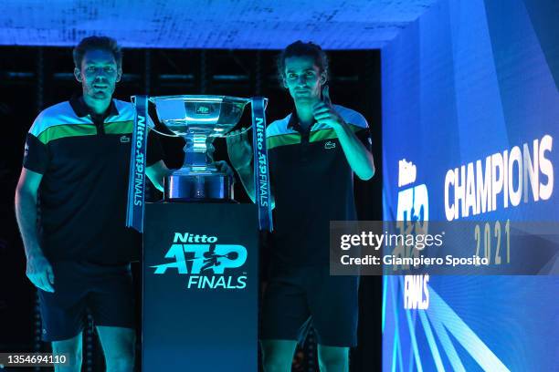 Nicolas Mahut and Pierre-Hugues Herbert of France pose for a photograph with the trophy following victory along with Joe Salisbury of Great Britain...