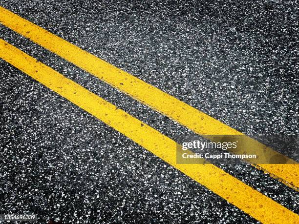 double yellow line in middle of road - yellow line stockfoto's en -beelden