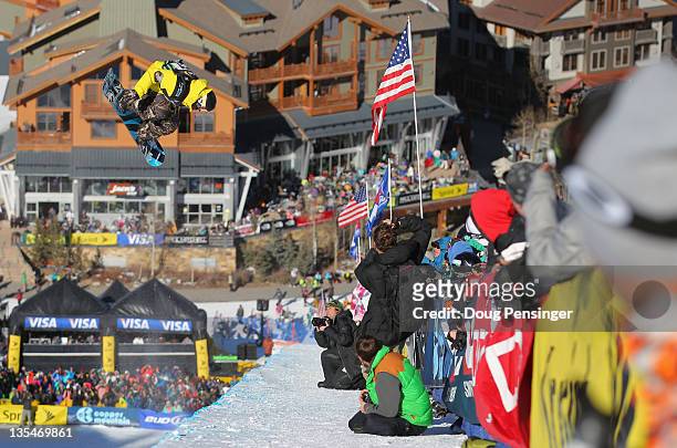 Luke Mitrani spins above the pipe, spectators and photographers as he rides to first place in the men's halfpipe finals of the Sprint US Snowboard...