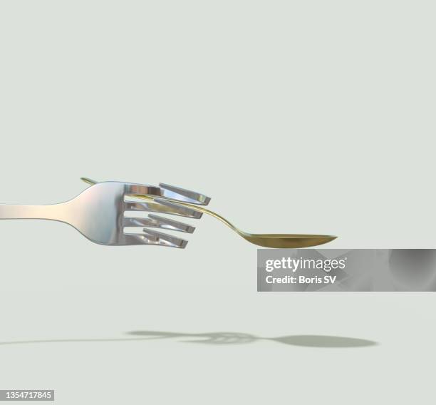 steel fork holding gold spoon - bent hand stock pictures, royalty-free photos & images